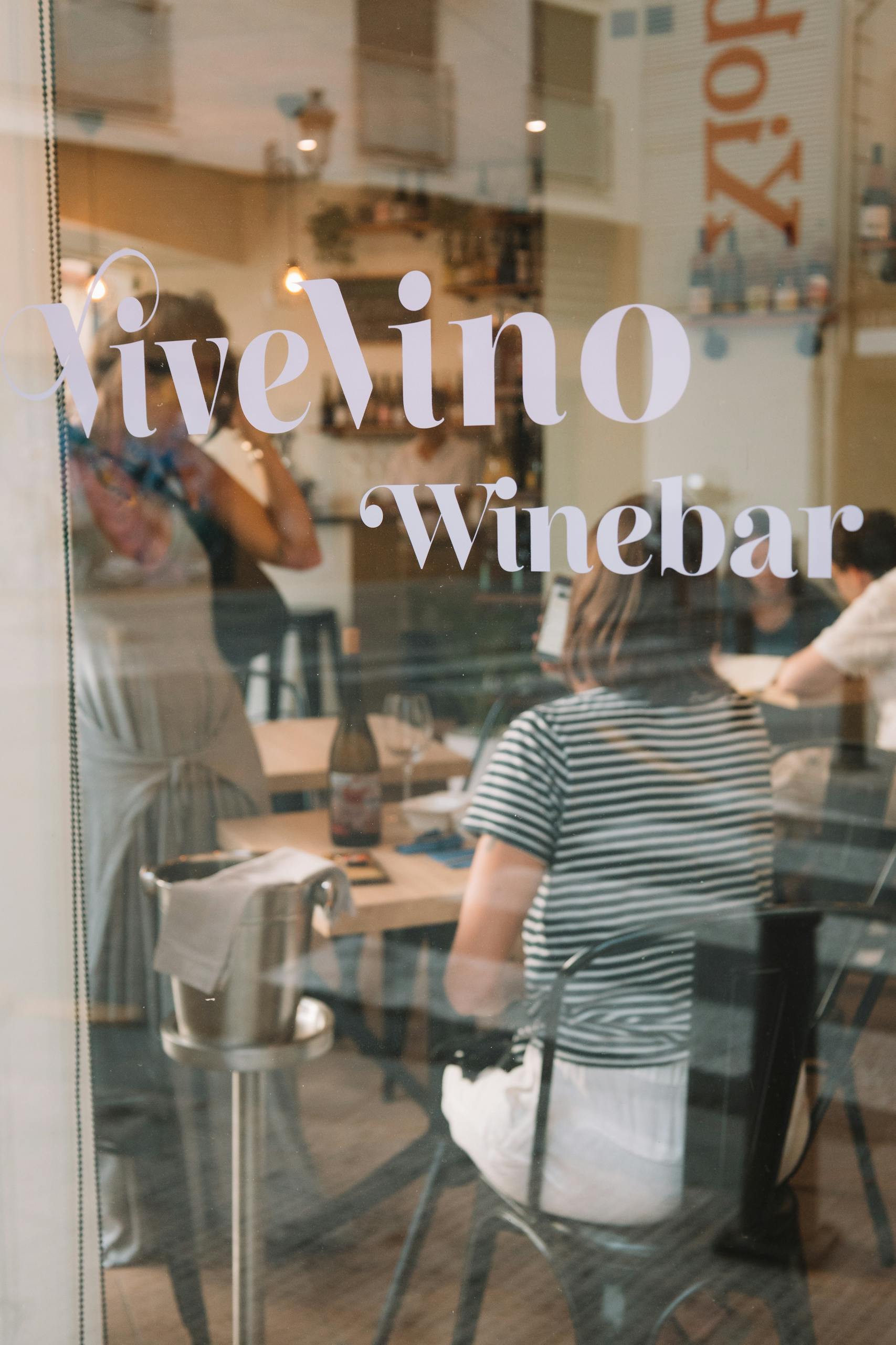 Cozy and elegant ambiance at Vivelino Winebar with patrons enjoying dining indoors.